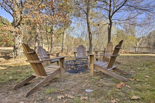 three wooden chairs sitting around a fire pit in a park at Retro Rhinelander Lake Retreat with Fire Pit! in Rhinelander
