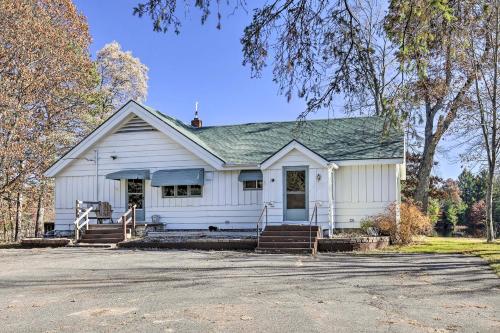 a white house with a porch and a driveway at Retro Rhinelander Lake Retreat with Fire Pit! in Rhinelander