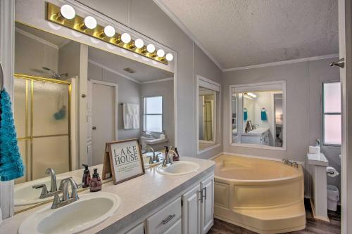 łazienka z 2 umywalkami, wanną i dużym lustrem w obiekcie Quiet Kingston Getaway Close to Lake Texoma! w mieście Kingston