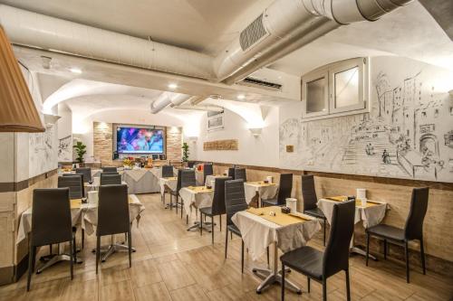Hotel Centro Cavour Roma في روما: مطعم بطاولات وكراسي وشاشة عرض