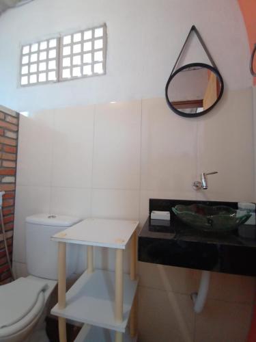 a bathroom with a toilet and a mirror on the wall at Chalé charmoso e aconchegante, pertinho da cidade. in Brasilia