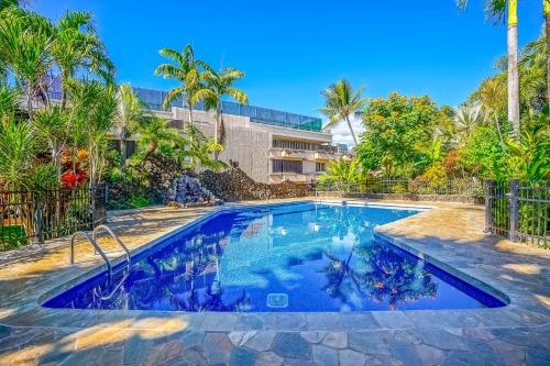 a swimming pool with blue water and palm trees at Prince Kuhio 323 in Koloa