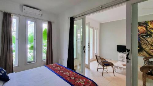 1 dormitorio con cama, ventana y silla en Starling villas, en Sanur