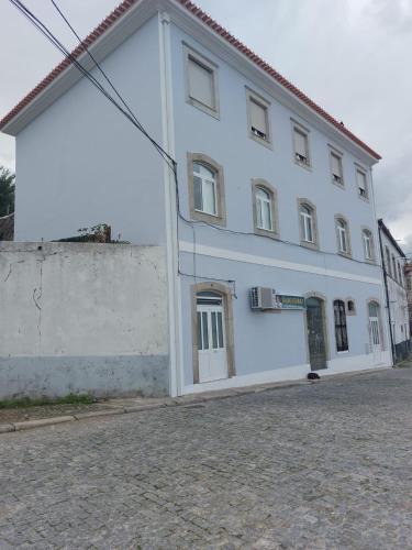 un grande edificio bianco sul lato di una strada di Al Boa Passagem a Peso da Régua