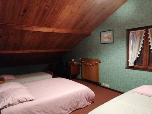 Saint-NabordにあるLes Vosges ça vous tente ?のベッドが2つあり、天井が木製の寝室