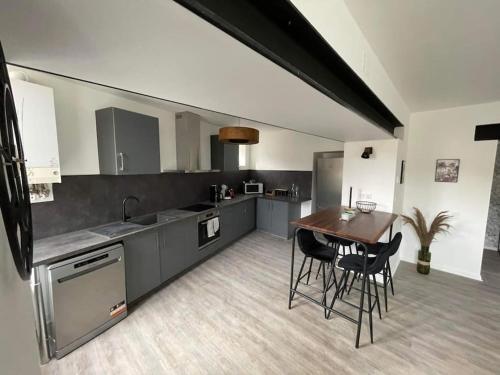 une cuisine avec une table et des chaises dans une pièce dans l'établissement Appartement Jungle- hypercentre -Charleville, à Charleville-Mézières