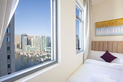 ein Schlafzimmer mit einem Fenster mit Hafenblick in der Unterkunft Dubai Marina Royal Premium Serviced Apartments Marina Wharf - KIDS STAY FREE in Dubai