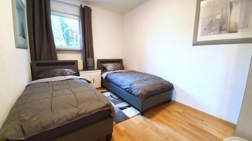 1 dormitorio con 2 camas y ventana en Living Hanau en Hanau am Main