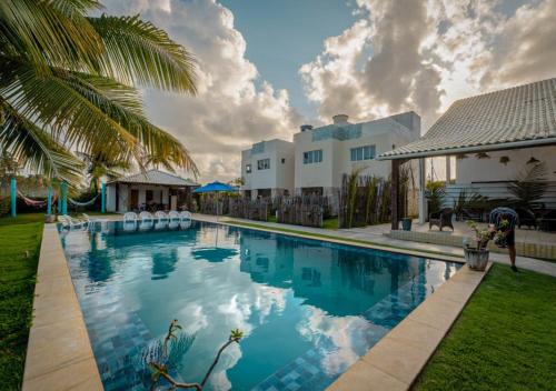 a swimming pool in front of a house at Reserva do Paiva suites in Cabo de Santo Agostinho