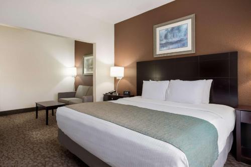 a hotel room with a large bed and a chair at Best Western Kendallville Inn in Kendallville