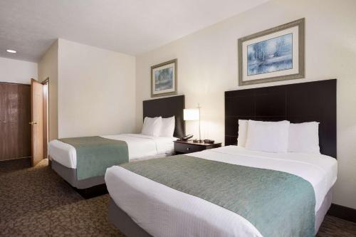 een hotelkamer met 2 bedden en 2 lampen bij Best Western Kendallville Inn in Kendallville