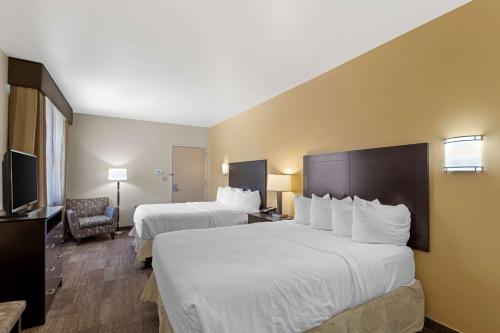 um quarto de hotel com duas camas e uma televisão em Best Western Pioneer em Lusk