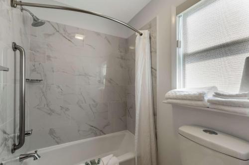 uma casa de banho branca com um chuveiro e um WC. em Best Western Pioneer em Lusk
