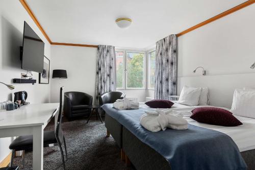Habitación de hotel con 2 camas y escritorio en Best Western Kom Hotel Stockholm en Estocolmo