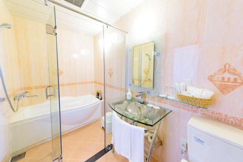 a bathroom with a sink and a tub and a shower at Best Western Okinawa Onna Beach in Onna