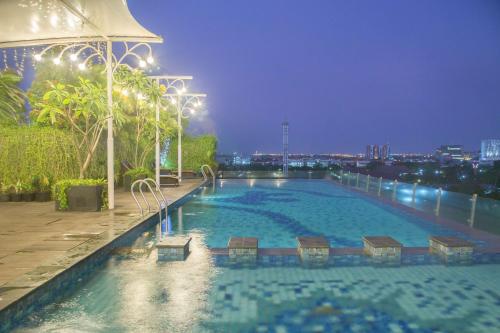 a large swimming pool on top of a building at night at Best Western Papilio Hotel in Surabaya