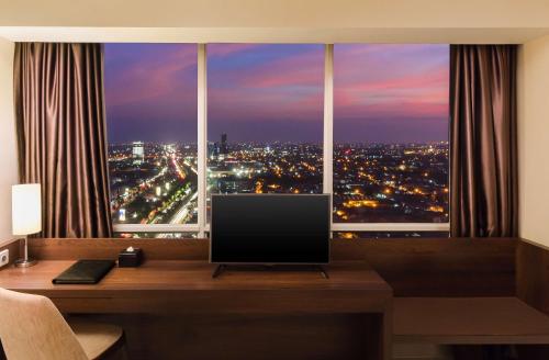 a computer monitor sitting on a desk in front of a window at Best Western Papilio Hotel in Surabaya