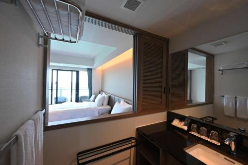 a bathroom with a large mirror in a hotel room at Best Western Okinawa Kouki Beach in Nago