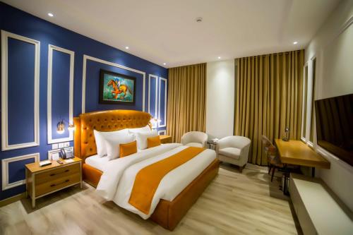 a hotel room with a large bed and a desk at Best Western Premier Hotel Gulberg Lahore in Lahore