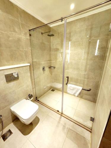 a bathroom with a shower and a toilet at Best Western Premier Hotel Gulberg Lahore in Lahore