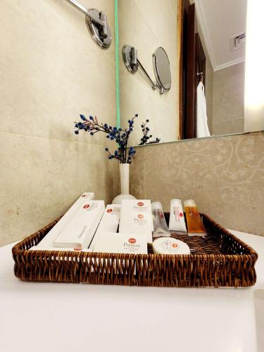 a bathroom counter with a wicker tray with sinks and a mirror at Best Western Premier Hotel Gulberg Lahore in Lahore