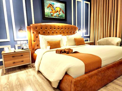 a bedroom with a large bed with a wooden headboard at Best Western Premier Hotel Gulberg Lahore in Lahore