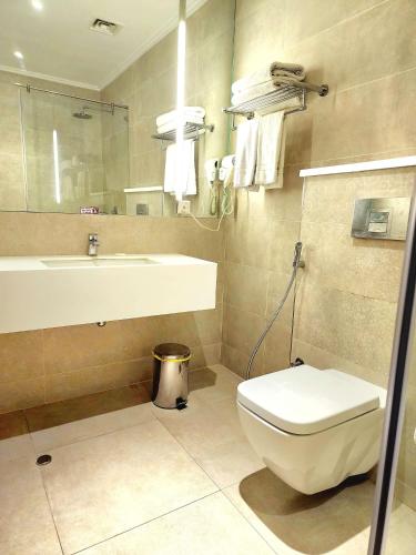 a bathroom with a toilet and a sink at Best Western Premier Hotel Gulberg Lahore in Lahore