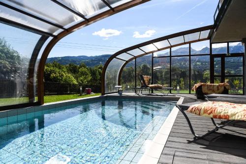 a swimming pool with an arched roof with a view at Auberge de l'Orangerie - Sure Hotel Collection by Best Western in Sallanches