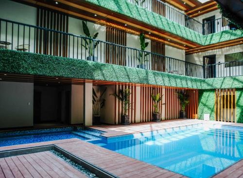 an indoor swimming pool in a building with plants at SureStay Studio by Best Western Clarkview Angeles City in Angeles