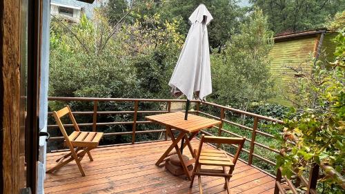a table and chairs on a deck with an umbrella at La Petite France in San José de Maipo