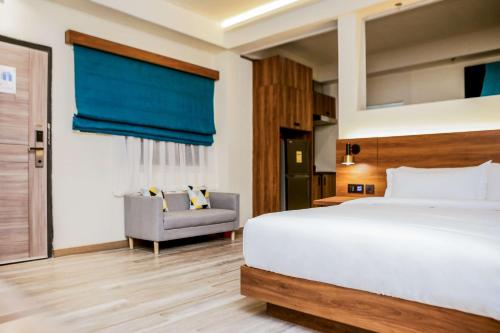 a bedroom with a large bed and a chair at SureStay Studio by Best Western Clarkview Angeles City in Angeles