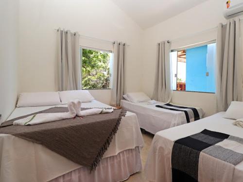 1 dormitorio con 2 camas y ventana en CASA do BRUNO ARRAIAL D'AJUDA, en Arraial d'Ajuda