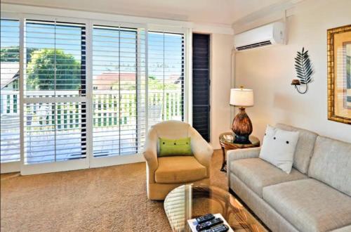 uma sala de estar com um sofá e uma cadeira em Kiahuna Plantation Unit 118 - 2nd Floor Expansive Views, Air Conditioning em Koloa