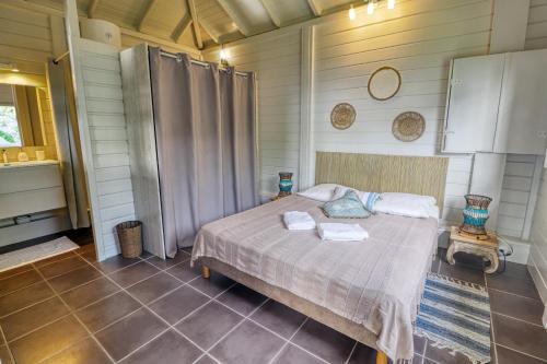 una camera da letto con un letto in una stanza di Bungalow proche plage a Sainte-Luce