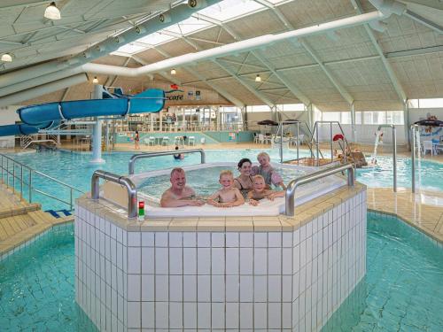 a group of people in a swimming pool at 6 person holiday home on a holiday park in Løkken in Løkken