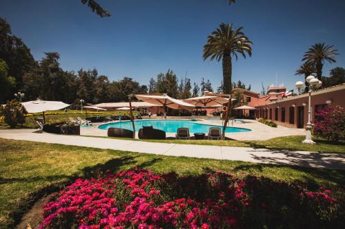 a resort with a swimming pool with pink flowers at Wyndham Costa del Sol Arequipa in Arequipa