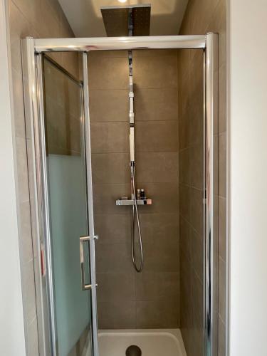 La salle de bains est pourvue d'une douche avec une porte en verre. dans l'établissement Le Villarois, à Nancy