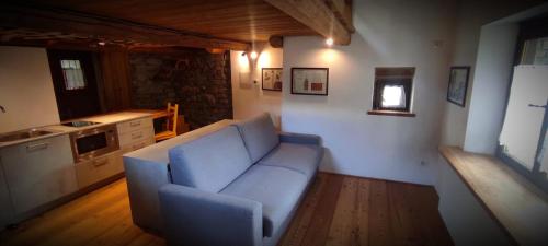 a living room with a blue couch and a kitchen at Vista Monterosa in Riva Valdobbia