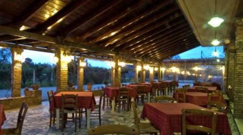 a restaurant with tables and chairs in a building at Fotis Rooms in Skafidia