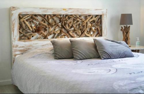 un letto con due cuscini davanti a un muro di La Maison Du Bois Flotté a Boulogne-sur-Mer