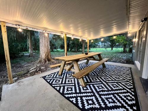 een picknicktafel op een tapijt op een patio bij Quiet Farmhouse close to major theme parks in Ridge Manor