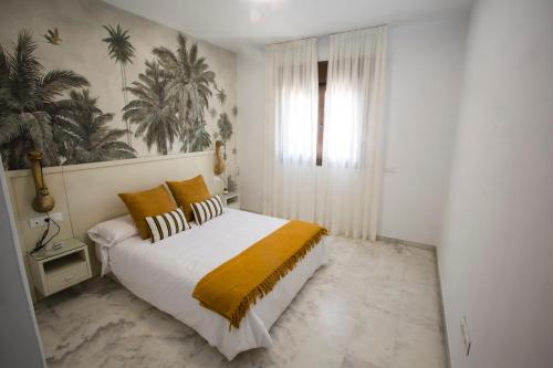 um quarto branco com uma cama com um cobertor amarelo em Alijar Lux Bormujos em Bormujos