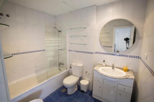 a bathroom with a toilet and a sink and a mirror at Alijar Lux Bormujos in Bormujos