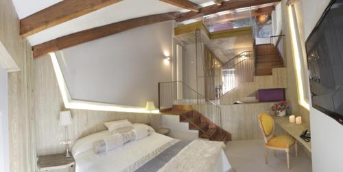 1 dormitorio con 1 cama grande y una escalera en Hotel Las Treixas, en Puebla de Sanabria