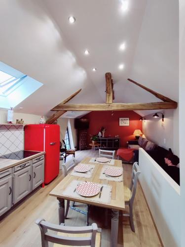 a kitchen and dining room with a table and a red refrigerator at La Mansarde in Vernon