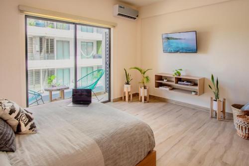 um quarto com uma cama e uma grande janela em Xifra Condos with ocean view pool em Playa del Carmen