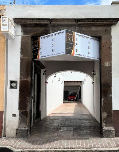 uma entrada para um edifício com duas placas por cima em Mina 18 em San Juan del Río