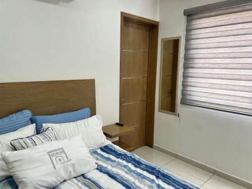 um quarto com uma cama com almofadas azuis e brancas em Mina 18 em San Juan del Río