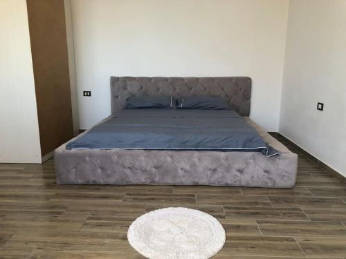 a large bed in a room with a rug at Sea View Deluxe Apartment in Durrës