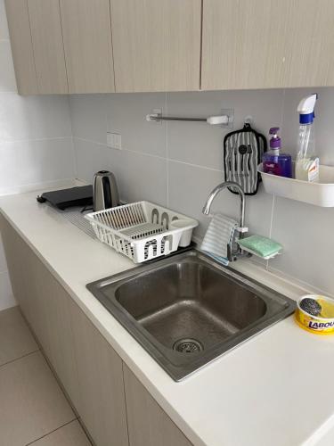 a kitchen sink with a dish drying rack next to it at Kaw Supreme Theme WIFI Luxury 7 PAX Genting Pool & Mountain View Cuti Genting Homestay Midhills in Genting Highlands